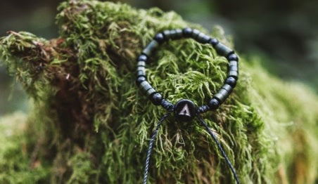 OMA bracelet on mossy log